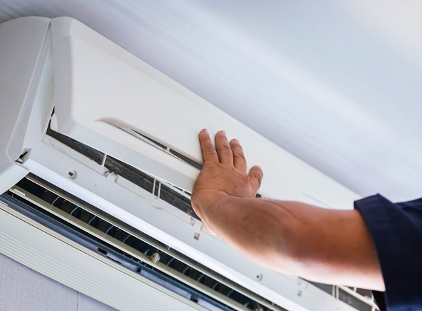 Technician performing maintenance on a ductless mini split AC system